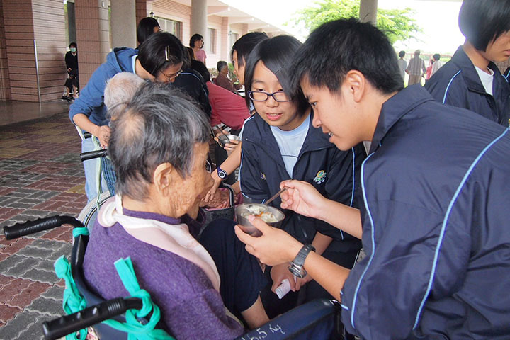 透由社會服務，林子瑜（照片右方餵飯者）學習陪伴、關心照顧老人，讓心的格局更寬廣。