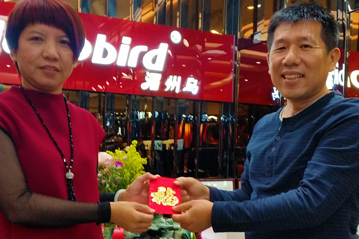 蓉姐（左）十分認同福智團體推廣背誦經典的理念，在將協助支出的費用交給高群超（右）時，還非常慎重地將費用放在紅包袋中。